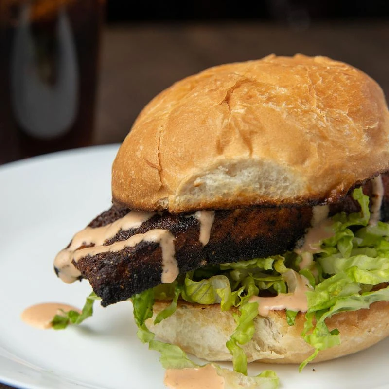 Blackened salmon sandwich with lettuce, served